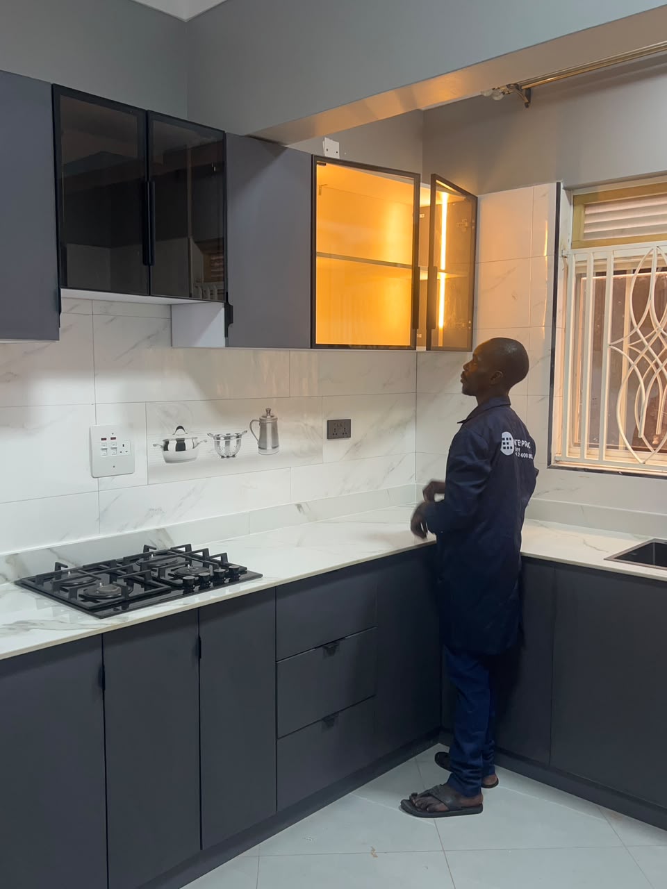 AFTER: the same kitchen fitted with grey cabinetry, white counters and illuminated glass upper cabinets